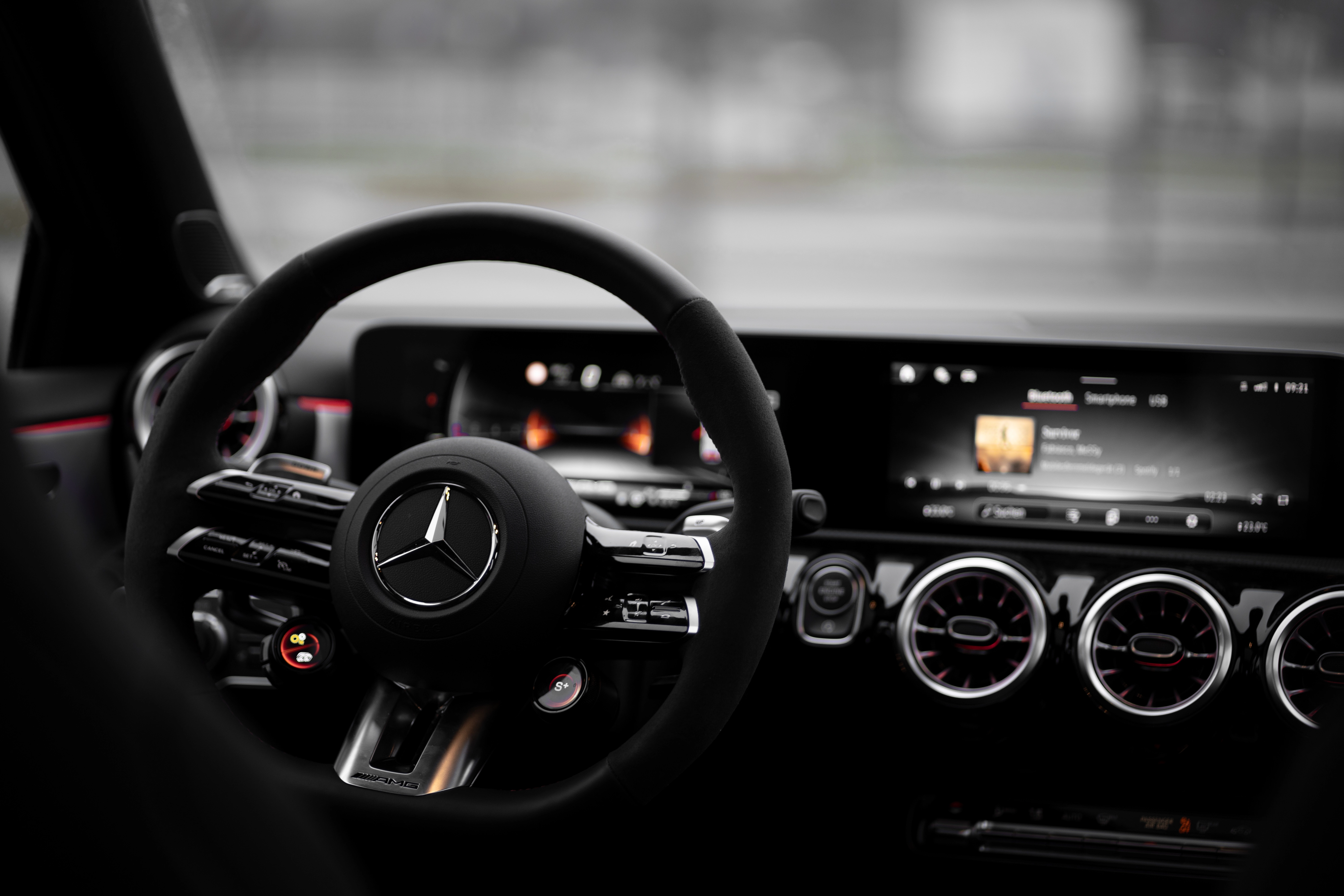 Innenraum Mercedes-AMG A 45 S mit Lenkrad, Displays und rotem Ambientelicht